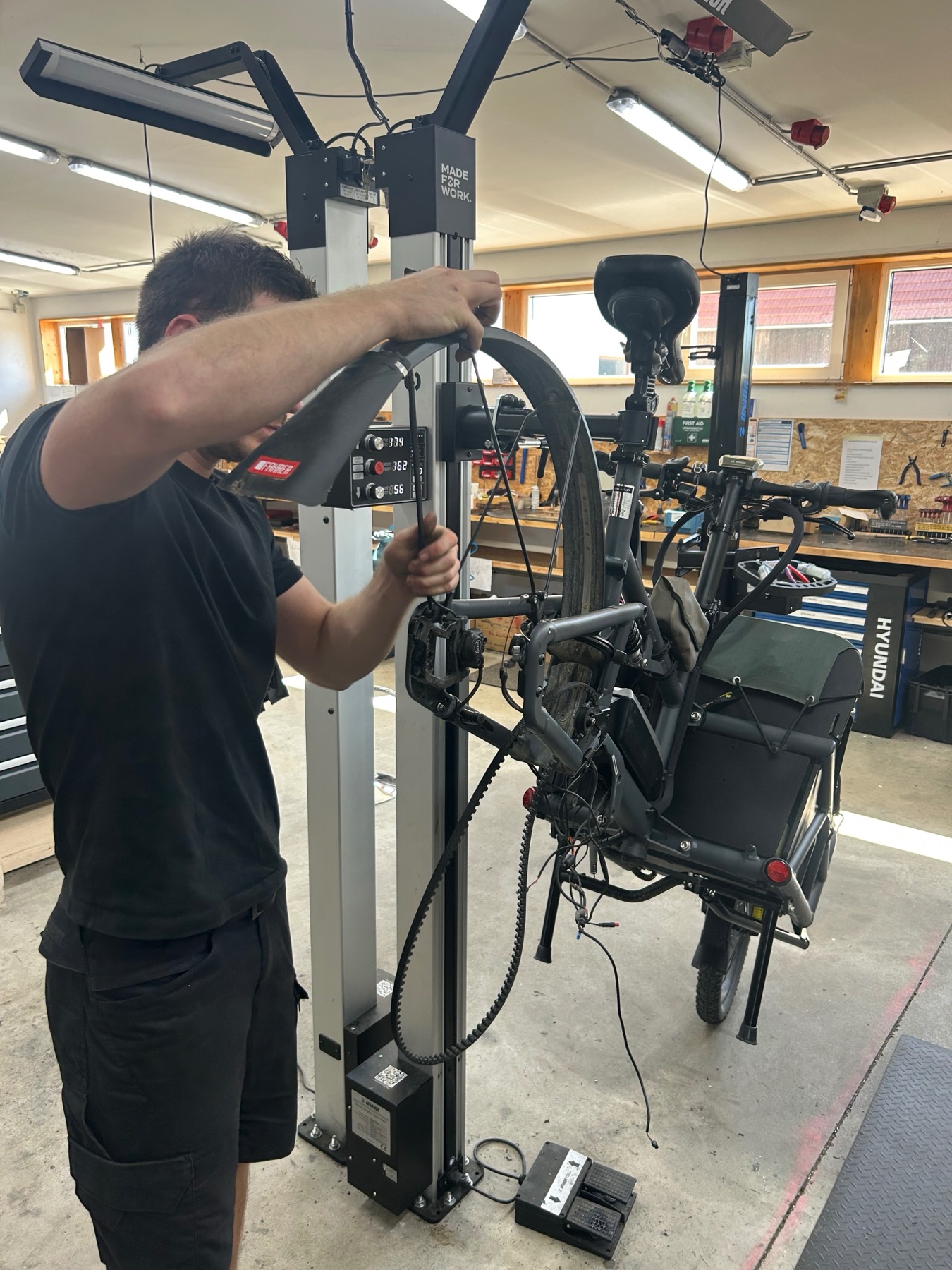 Mechaniker prüft ein E-Bike im Montageständer in der Werkstatt